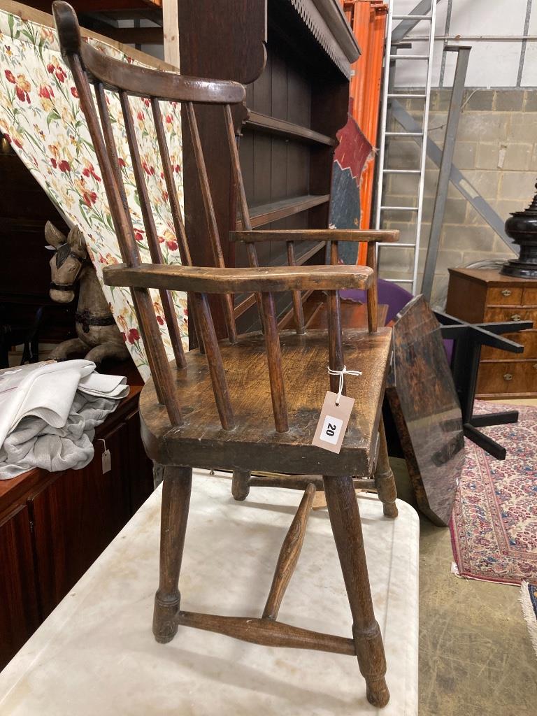An early 19th century, possibly Welsh ash and fruitwood primitive Windsor comb back elbow chair, width 59cm, depth 40cm, height 90cm
